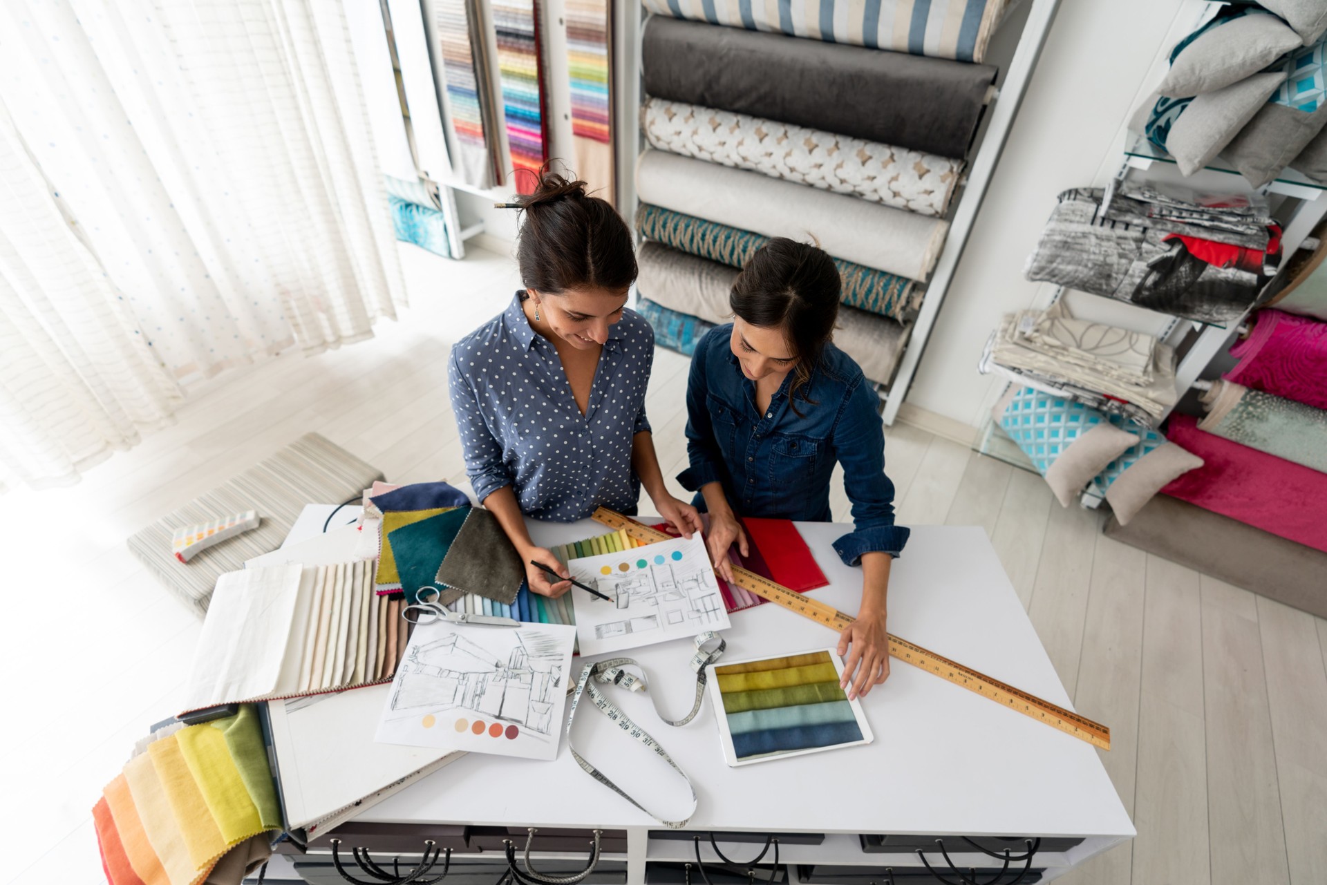 Interior designer with a woman choosing fabrics for a house project